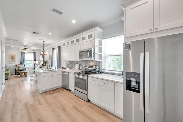 kitchen featuring white cabinetry, light hardwood / wood-style flooring, appliances with stainless steel finishes, decorative light fixtures, and ceiling fan