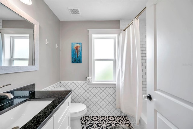 bathroom featuring vanity, tile walls, toilet, and tile patterned floors