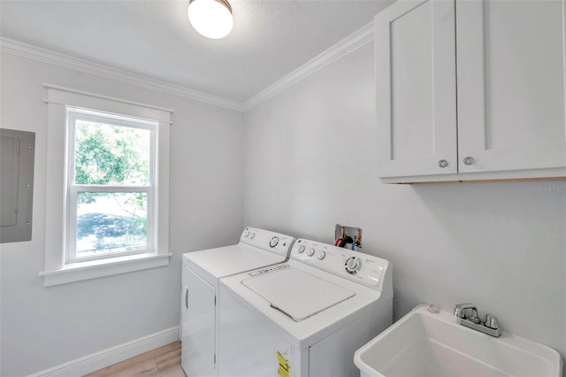 clothes washing area with cabinets, light wood-type flooring, electric panel, sink, and washing machine and clothes dryer