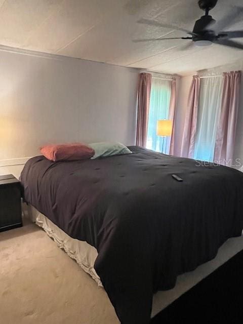 bedroom featuring ceiling fan and carpet