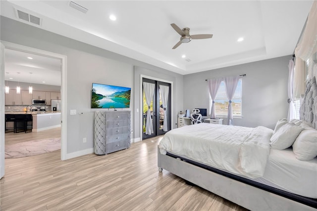 bedroom featuring white refrigerator with ice dispenser, a raised ceiling, ceiling fan, access to exterior, and light hardwood / wood-style floors