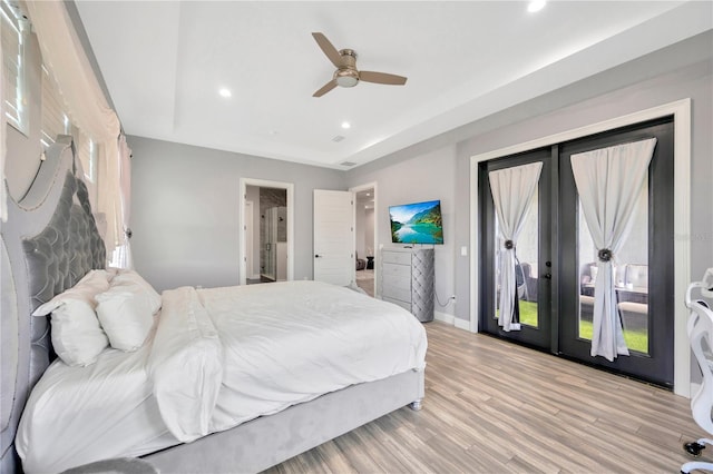 bedroom with a raised ceiling, access to exterior, ceiling fan, and french doors