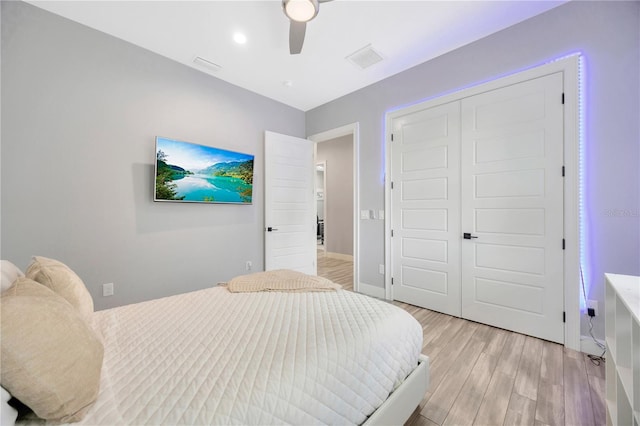 bedroom with a closet, light hardwood / wood-style flooring, and ceiling fan