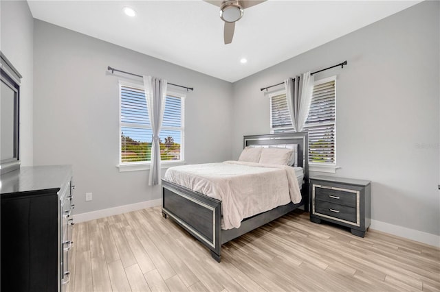 bedroom featuring ceiling fan, light wood-type flooring, and multiple windows