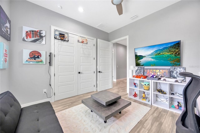 living room with light wood-type flooring and ceiling fan