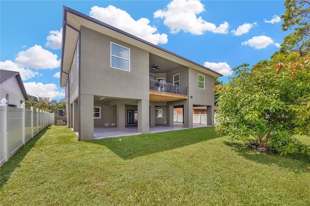 back of house with a lawn, ceiling fan, a balcony, and a patio