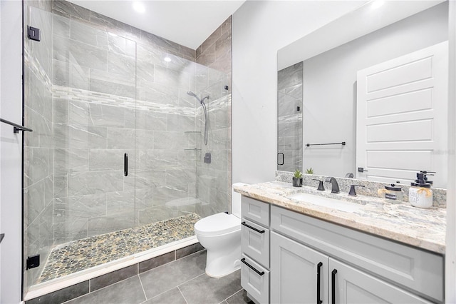 bathroom featuring tile patterned flooring, vanity, toilet, and walk in shower