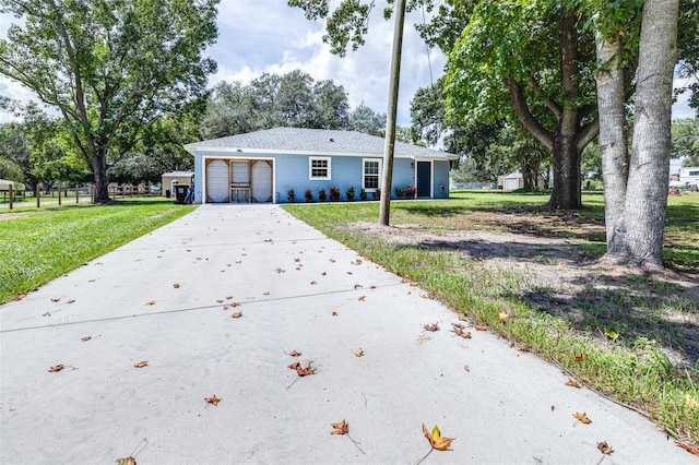 ranch-style home featuring an attached garage, concrete driveway, and a front lawn