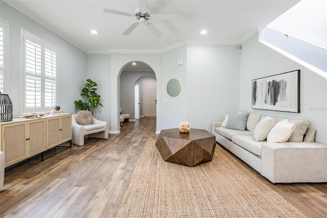 living room featuring ornamental molding, light hardwood / wood-style flooring, and ceiling fan