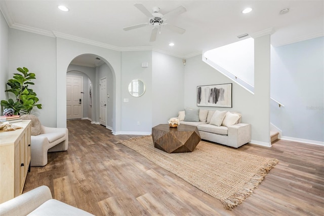 living room featuring hardwood / wood-style floors, ceiling fan, and ornamental molding