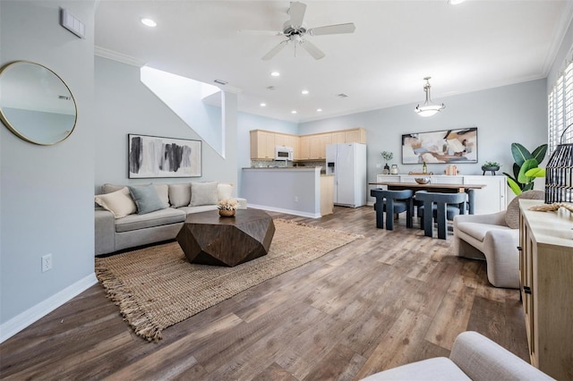 living room featuring dark wood-type flooring, ceiling fan, and ornamental molding