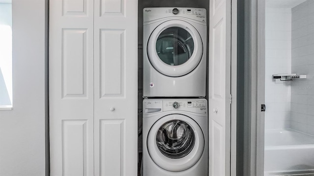 washroom with stacked washing maching and dryer