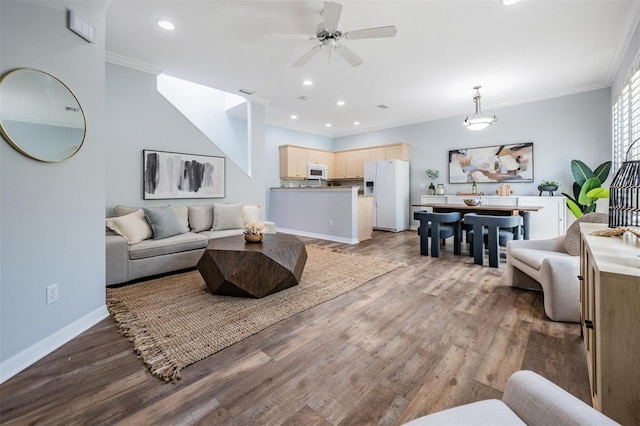 living area with crown molding, baseboards, dark wood-style flooring, and recessed lighting