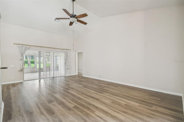 empty room with high vaulted ceiling, hardwood / wood-style floors, and ceiling fan