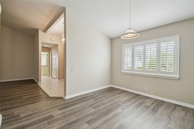 empty room featuring a textured ceiling and hardwood / wood-style floors