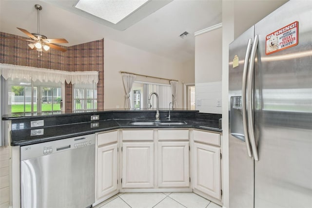 kitchen with light tile patterned floors, stainless steel appliances, sink, ceiling fan, and white cabinets