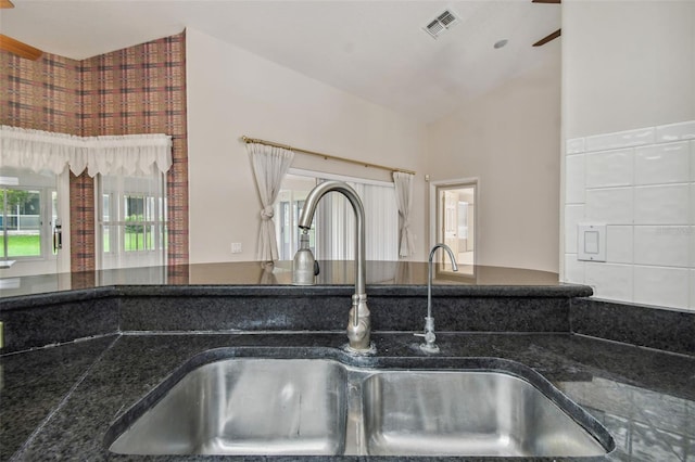 details with ceiling fan, sink, and dark stone countertops