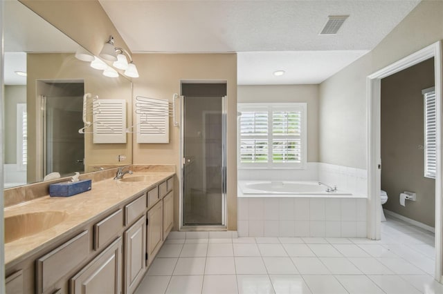 full bathroom featuring tile patterned flooring, toilet, shower with separate bathtub, vanity, and a textured ceiling