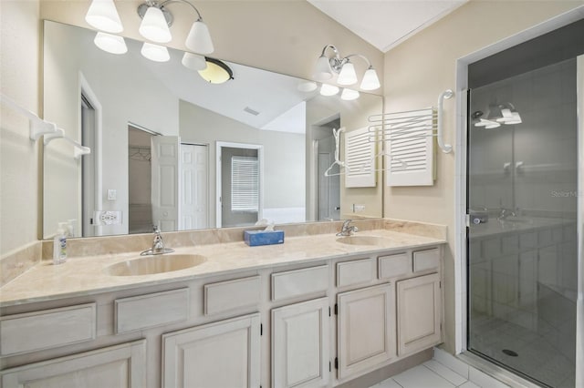 bathroom with tile patterned flooring, vaulted ceiling, walk in shower, and vanity