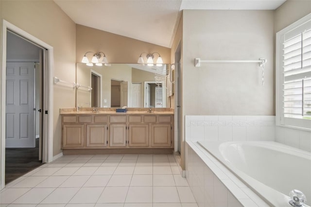 bathroom featuring lofted ceiling, tile patterned flooring, tiled tub, and vanity