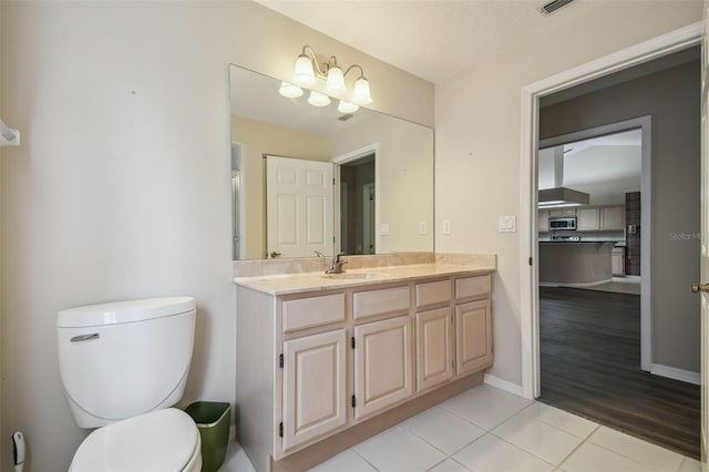 bathroom with vanity, toilet, and wood-type flooring