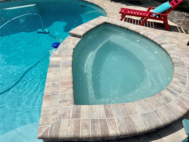 view of swimming pool with an in ground hot tub