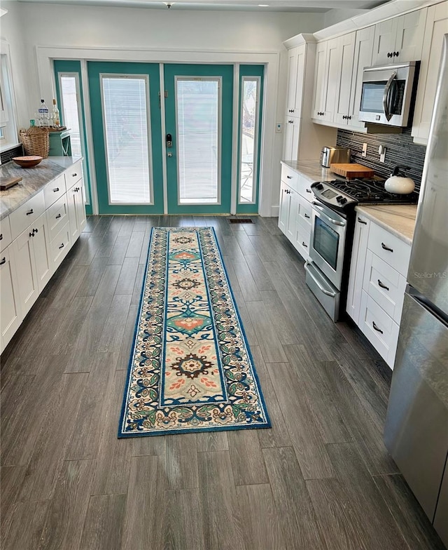 kitchen featuring white cabinets, a healthy amount of sunlight, and appliances with stainless steel finishes