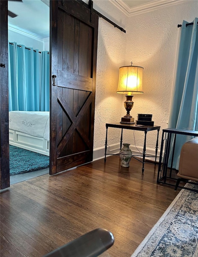 interior space with dark hardwood / wood-style flooring, a barn door, and ornamental molding