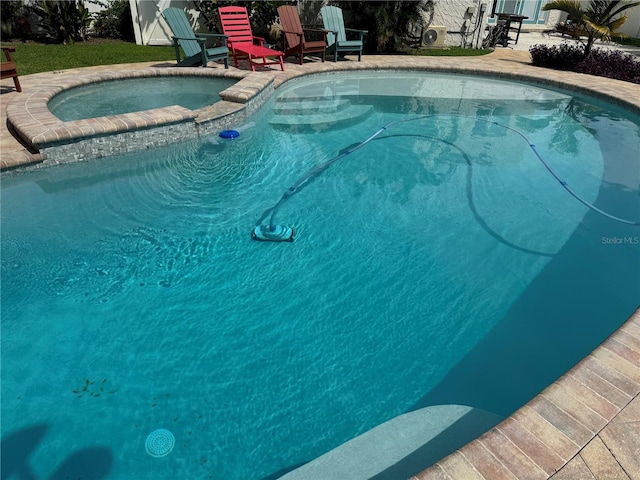 view of swimming pool with an in ground hot tub