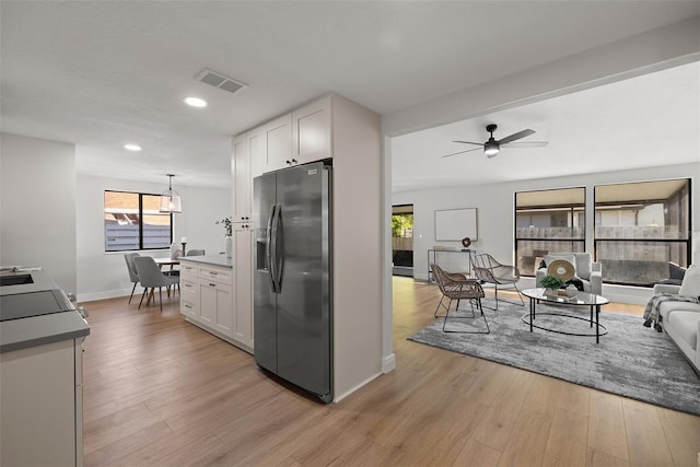 kitchen with light hardwood / wood-style floors, white cabinetry, ceiling fan, and stainless steel fridge with ice dispenser