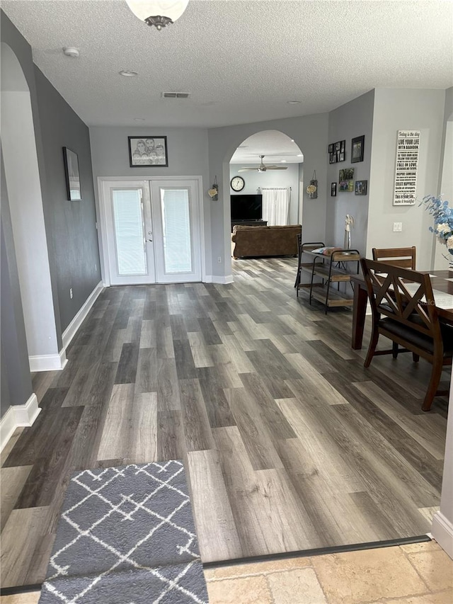 interior space featuring dark wood-type flooring, a textured ceiling, and french doors