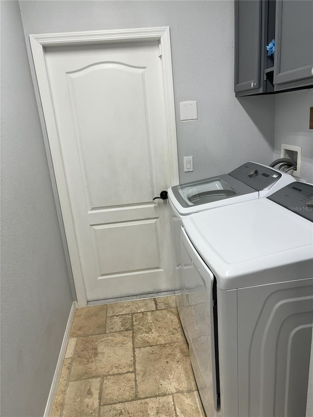 laundry room featuring separate washer and dryer and cabinets