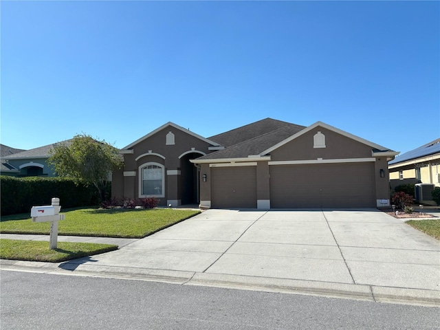 ranch-style home with a garage, central AC unit, and a front yard