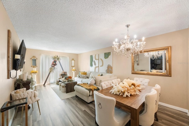 dining space with a textured ceiling, a notable chandelier, and wood-type flooring