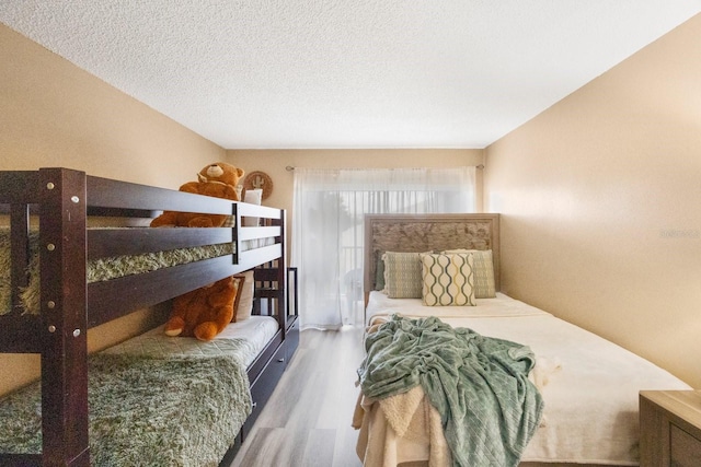 bedroom with a textured ceiling and hardwood / wood-style floors