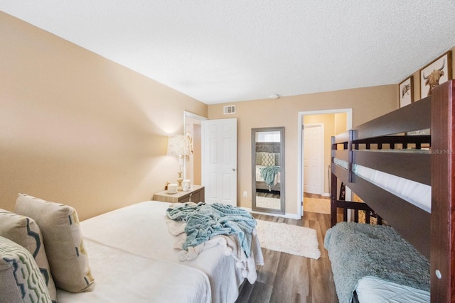 bedroom featuring wood-type flooring and a textured ceiling