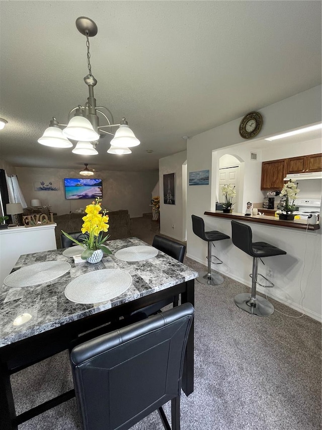 carpeted dining area featuring a chandelier