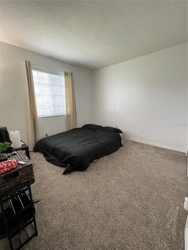 bedroom with a textured ceiling and carpet flooring