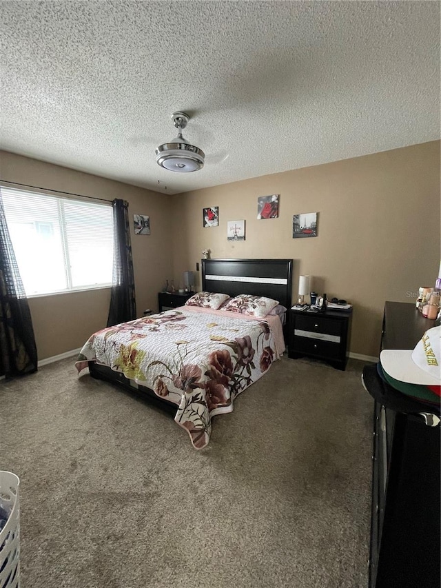 carpeted bedroom featuring ceiling fan and a textured ceiling