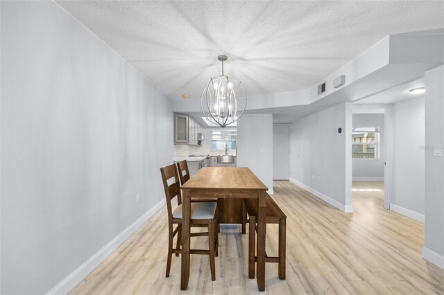 dining room featuring a wealth of natural light, light hardwood / wood-style flooring, and an inviting chandelier