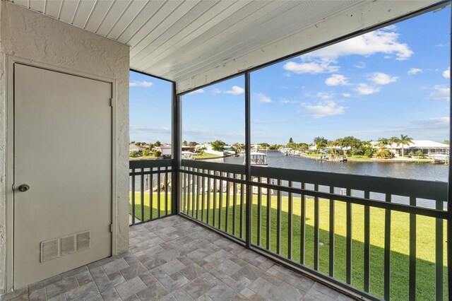 unfurnished sunroom featuring a water view