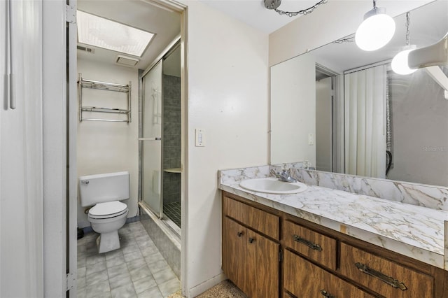 bathroom featuring a skylight, tile patterned flooring, walk in shower, toilet, and vanity