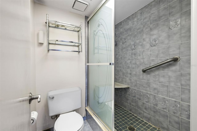 bathroom featuring toilet and a shower with door