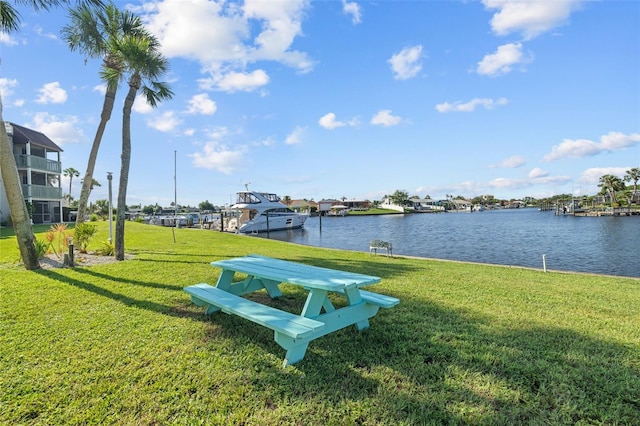 surrounding community with a yard and a water view