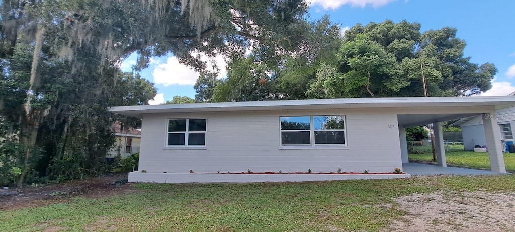 exterior space featuring a lawn and a carport