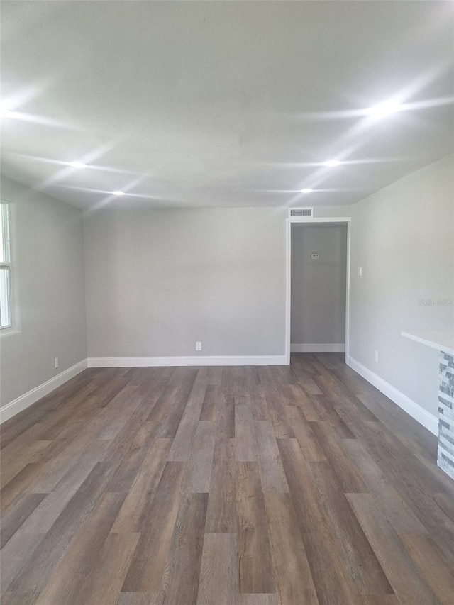 unfurnished room with dark hardwood / wood-style flooring