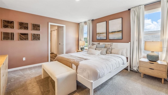 bedroom with baseboards and light carpet