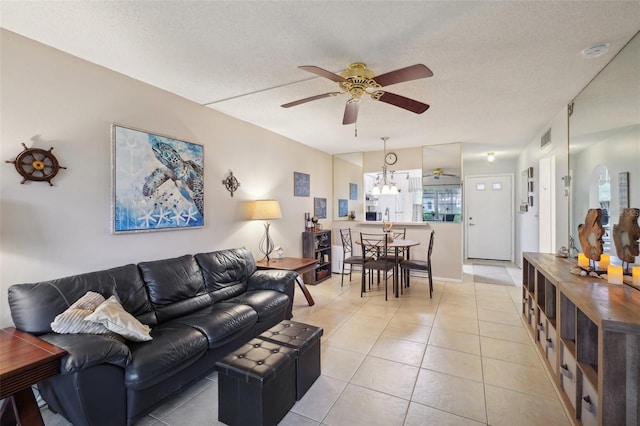 living room with a textured ceiling, light tile patterned floors, and ceiling fan