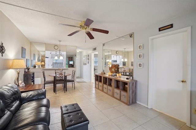 living room featuring a textured ceiling, light tile patterned flooring, and ceiling fan