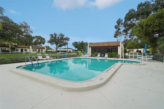 view of pool featuring a lawn and a patio